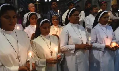  ?? Photograph: Arif Ali/ AFP/Getty Images ?? Christians and Muslims in Lahore, Pakistan, hold candles at a tribute to the victims of the Sri Lanka bomb blasts.