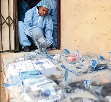  ?? PICTURES: NOKUTHULA MBATHA ?? CRIME SCENE: Constable Ntsoaki Manyanye gathers evidence at a house in Naledi, Soweto, where guns, cellphones and expensive watches were found hidden in a mattress yesterday.