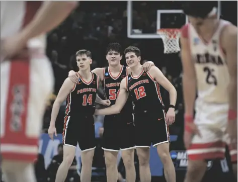  ?? JOSÉ LUIS VILLEGAS/AP ?? PRINCETON GUARD MATT ALLOCCO (14) forward Zach Martini (54) and forward Caden Pierce (12) and teammates embrace in the final seconds of the second half of a first-round game against Arizona in the NCAA Tournament in Sacramento, Calif., on Thursday.