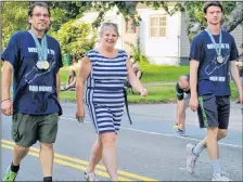  ?? KATHY JOHNSON PHOTO ?? Shelburne County Special Olympics athletes Daniel Hopkins, left, and Ashley Rennehan wear their medals from the National Games as they walk with Queens Shelburne MLA Kim Masland in the Shelburne County Exhibition parade.