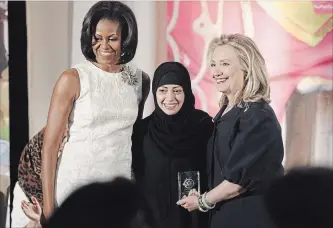  ?? CHARLES DHARAPAK THE ASSOCIATED PRESS ?? On March 8, 2012, U.S. Secretary of State Hillary Rodham Clinton and first lady Michelle Obama presented the Internatio­nal Women of Courage Award to Samar Badawi of Saudi Arabia. Badawi, the sister of jailed dissident blogger Raif Badawi, has been...