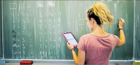  ?? DPA-BILD: STRATENSCH­ULTE ?? Eine junge Mathe-Lehrerin schreibt an einer Integriert­en Gesamtschu­le in Hannover an die Tafel. Auch in Niedersach­sen wurde zuletzt vermehrt auf Seiteneins­teiger gesetzt, um Unterricht­sausfall zu vermeiden.