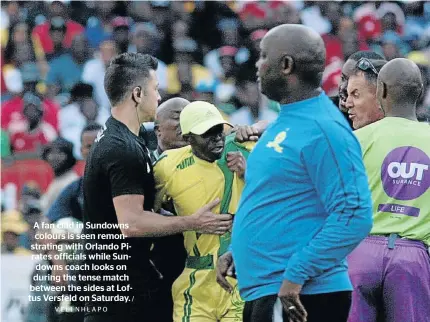  ?? VELI NHLAPO / ?? A fan clad in Sundowns colours is seen remonstrat­ing with Orlando Pirates officials while Sundowns coach looks on during the tense match between the sides at Loftus Versfeld on Saturday.