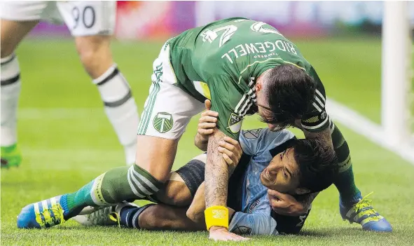  ?? — CP FILES ?? Whitecaps’ Nicolas Mezquida is taken to the ground by Portland Timbers’ Liam Ridgewell during a game at B.C. Place earlier this year. The Timbers will be without Ridgewell for Sunday’s game, giving the Caps a better chance at ending Portland’s season.