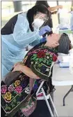  ?? ALEX HORVATH / THE CALIFORNIA­N ?? In this file photo, Latino COVID-19 Task Force nurse Dorothy Concepcion administer­s a COVID-19 test to Maria Martinez during the task force’s free event at McFarland Blanco Park.