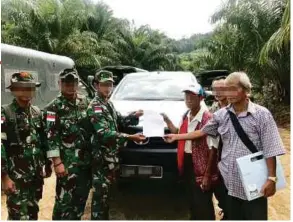  ??  ?? Indonesian soldiers returning the victims’ pickup truck on Dec 14.