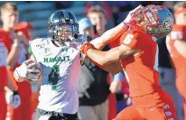  ?? JIM THOMPSON/JOURNAL ?? Hawaii’s Kumoku Noa (4) keeps UNM’s De’John Rogers at a distance on the way to a 54-yard touchdown reception.