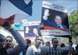  ?? Jonathan Rashad For The Times ?? PEOPLE SHOW their support for Egyptian President Abdel Fattah Sisi outside a polling station in Cairo this week. Voter turnout was lower than four years ago.