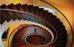  ??  ?? Holland Williams, director of marketing for the Historic Charleston Foundation, walks down the cantilever­ed stairs at the Nathaniel Russell House.