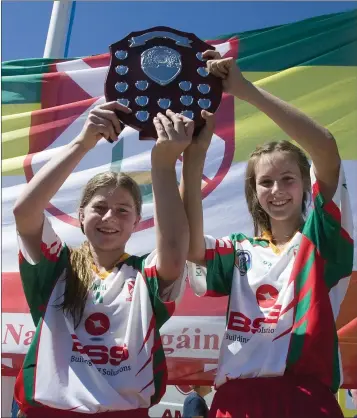  ??  ?? Kiltegan’s Sophie Bermingham and Hope Tallon lift the shield.