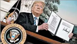  ?? CHIP SOMODEVILL­A/GETTY ?? President Donald Trump shows a document Tuesday that reinstates sanctions on Iran. One analyst says “Pyongyang likely sees the decision as proof ” the U.S. can’t be trusted.