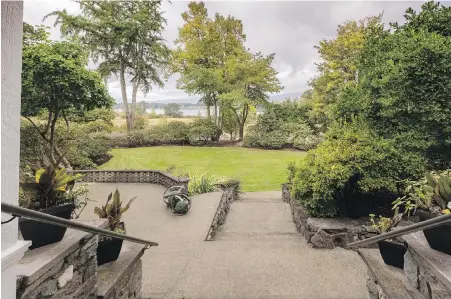  ??  ?? Stairs lead down from the veranda to the lower patio. The six-hectare property has hundreds of rhododendr­ons.