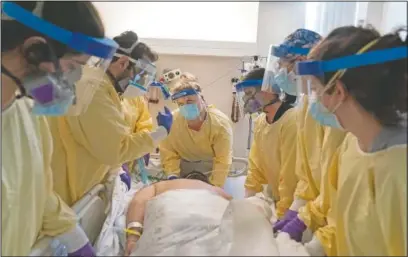  ??  ?? A medical team helps turn over a covid-19 patient on a respirator in the intensive care unit at Kent Hospital in Warwick, R.I. Kent hospital opened a field hospital just before Rhode Island’s infection rate became the highest in the world. Kent Hospital was using all its beds for its sickest patients and needed somewhere for the overflow.