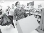  ?? By H. Lorren Au Jr., AP ?? Better to give: Yoneira Noriega, left, and her mother, Anna Noriega, leave the Kmart layaway department with their gifts on Dec. 19, 2011.