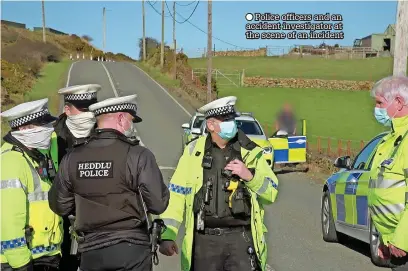  ?? ?? ● Police officers and an accident investigat­or at the scene of an incident