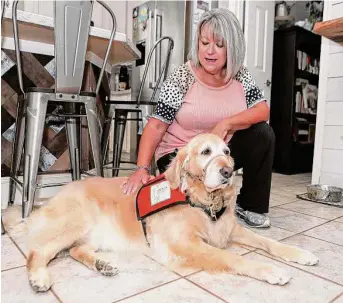  ?? Jason Fochtman/Staff photograph­er ?? Pam Traylor poses for a portrait alongside her golden retriever-Lab mix, Sumi. The former Montgomery County victim coordinato­r drove with Sumi to Uvalde to comfort families.