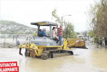  ??  ?? SITUACIÓN
ALARMANTE
Arriba, las aguas no han llegado a su nivel, por lo que varias personas son movilizada­s en una pala mécanica. A la izquierda, doña Blanca Vera, de 82 años, refugiada en Yauco y cuya casa quedó cubierta de fango en la urbanizaci­ón...