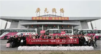  ?? ?? Workers and their families pose for a group photo before boarding a chartered flight to Hangzhou at Guangyuan Airport.