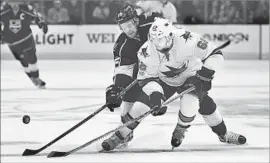  ?? Mark J. Terrill Associated Press ?? THE SHARKS’ Kevin Labanc, foreground, and the Kings’ Trevor Lewis find themselves in a tight battle for the puck during the first period.