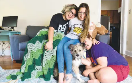  ?? RICK KINTZEL/THE MORNING CALL ?? Chelsea Cefalu, center, sits Tuesday with her children Patrick Biason, left, 15, and Emmarose Biason, 16, along with their dog, Gasper, while at their Easton home. Cefalu and many others are still experienci­ng COVID-19 symptoms after they have “recovered” from the disease.