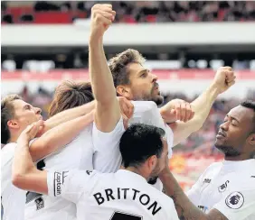  ??  ?? > Swans players mob Fernando Llorente after the big striker’s opener