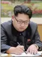 ?? KNS ?? NORTH KOREA’S Kim Jong Un signs a document Jan. 3 authorizin­g a hydrogen bomb test.