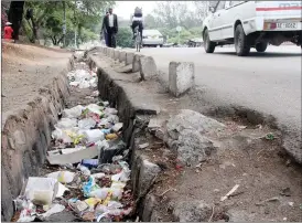  ??  ?? A Bulawayo City Council van drives past a storm drain blocked with litter near Basch Street Bus Terminus recently. With the onset of the rains the clogged drains are likely to discharge their contents onto the streets.— (Picture by Nkosizile Ndlovu)