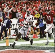  ?? Curtis Compton / TNS ?? Georgia defensive back Kelee Ringo intercepts Alabama and returns it for a touchdown in the College Football Playoff Championsh­ip game in 2022 in Indianapol­is.