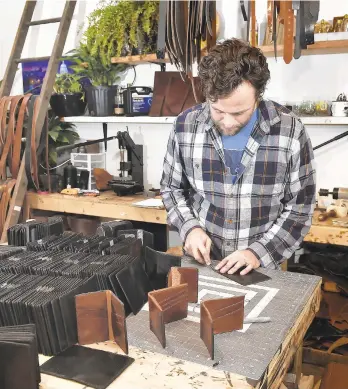  ?? SUZETTEWEN­GER/AP ?? Michael Glick of Black Bear Leather works in his Lancaster shop last month, where he was making wallets for members of Congress.