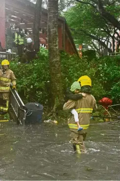  ?? — Agencies ?? Taking a beating: (From top, clockwise): A Hong Kong fireman helping a child cross a flooded street at the village of Lei Yu Mun.A giant wave striking the coast in Hong Kong. Residents in Shenzhen, China, stocking up on bottled water at a supermarke­t in preparatio­n for Typhoon Mangkhut. A woman struggling with her umbrella in Shenzhen.