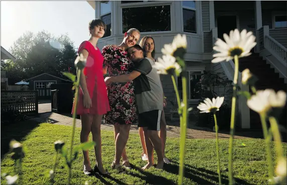  ?? CHAD HIPOLITO/FOR PNG ?? Mary Ellen Turpel-Lafond with three of her kids — 14-year-old twin daughters Isobel, left, and Portia, right, and Isaiah, 12 — in the garden of their Victoria home. ‘Being a parent makes me better at my job,’ says B.C.’s Representa­tive for Children and Youth.