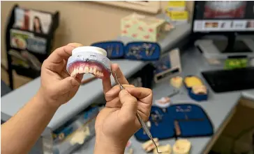  ??  ?? Denture clinician Thomas Gu crafts a set of highly realistic dentures at Merivale Denture Clinic last week.