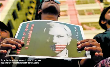  ?? Foto: AFP ?? Un activista sostiene un cartel, junto a otros, que reclama la libertad del fundador de WikiLeaks.