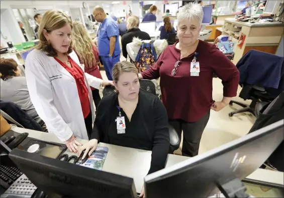  ?? FRANK FRANKLIN II — THE ASSOCIATED PRESS ?? Kathleen Sheehan, left, director of Emergency and Trauma Services, speaks with Sarah Horn, center, and Lead Case Manager Jeanne Icolari in the Emergency room at St. Luke’s Cornwall Hospital in Newburgh, N.Y. The hospital adopted the Hudson Valley Interlink Analytic System earlier this year, which tracks drug overdoses in New York. The system is among a number of surveillan­ce systems being adopted around the country by police, government agencies and community groups.