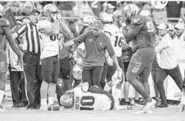  ?? AILEEN PERILLA/ORLANDO SENTINEL ?? UCF quarterbac­k Mackenzie Milton (10) grabs right leg after geting tackled by the USF defense, injuring his leg Friday at Raymond James Stadium.