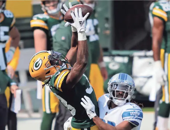  ?? DAN POWERS/USA TODAY NETWORK ?? Packers running back Aaron Jones hauls in a reception over Lions cornerback Darryl Roberts. Jones scored three touchdowns Sunday.