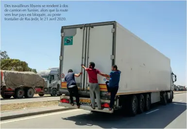  ??  ?? Des travailleu­rs libyens se rendent à dos de camion en Tunisie, alors que la route vers leur pays est bloquée, au poste frontalier de Ras Jedir, le 21 avril 2020.