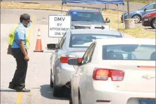  ?? Ned Gerard / Hearst Connecticu­t Media ?? A security guard checks in drivers as they arrive for appointmen­ts Tuesday at the state Department of Motor Vehicles office in Bridgeport.