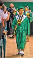  ??  ?? Avery Torrez walks into the graduation ceremony at Pojoaque Valley High School last month.