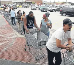  ?? Picture: Getty. ?? People queue to buy groceries in the Chanelview area of Houston as flood waters begin to recede.