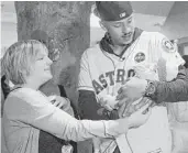  ??  ?? Carlos Correa said he was more nervous to hold 11-day-old Zoey Weinlein, with her mother, Nicole, than he was in Game 7 of the World Series.