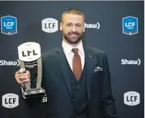  ??  ?? The Edmonton Eskimos’ Mike Reilly displays his most outstandin­g player award in Ottawa on Thursday. NATHAN DENETTE/THE CANADIAN PRESS