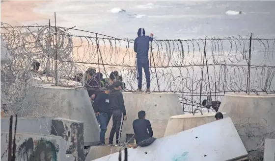  ?? ?? Palestinia­nos na praia perto da fronteira entre a Faixa de Gaza e o Egito, no campo de refugiados de Rafah.