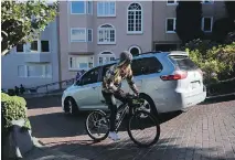  ?? ERIC RISBERG/THE ASSOCIATED PRESS ?? A cyclist tries to ride up Lombard Street against one-way traffic. The crooked block has grown so chaotic that San Francisco is considerin­g banning cars or charging a toll for driving the winding street.