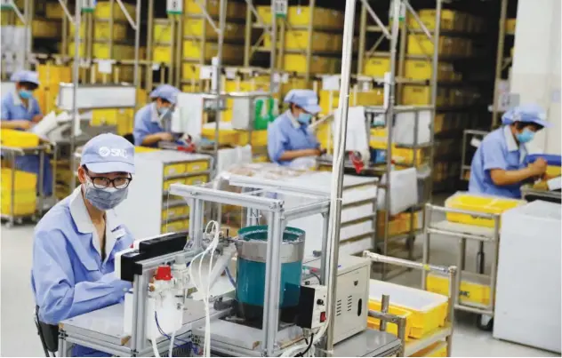  ?? ?? ±
Employees work at a factory of the component maker SMC in Beijing, China. Reuters