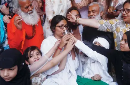  ?? Reuters ?? Girls offer juice to Swati Maliwal to end her fast during her hunger strike protest demanding stricter laws for rape in India, in New Delhi on Sunday.