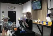  ?? (AP/Stephen Groves) ?? Kayla Snedeker (right) assists a customer at The Flower Shop Dispensary, a medical marijuana retail facility, in Sioux Falls, South Dakota on Friday. The dispensary opened after South Dakota voters legalized medical marijuana in 2020.