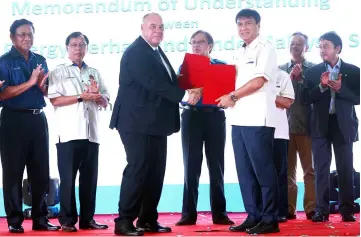  ??  ?? Abang Johari (centre) witnessing the exchange of MoU between Sharbini (third right) and Hughes (third left). Looking on are Dr Rundi (second left), Dr Abdul Rahman (left), Liwan (second right) and others.