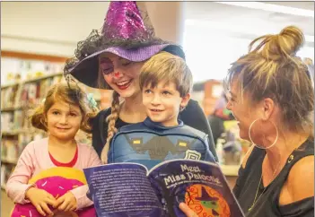  ?? Michele Lutes/The Signal (See additional photos at signalscv.com) ?? Scarlett and Samuel read “Meet Miss Patootie” with Mary Baxter-Jordan and her daughter Lauren Jordan who is dressed as the titular character in Baxter’s book at Old Town Newhall Library on Wednesday.