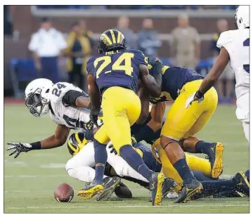  ??  ?? Miles Sanders fumbles late in the game for Penn State, well after No. 4 Michigan was on its way to a 49-10 win in the Big Ten Conference opener for both teams.